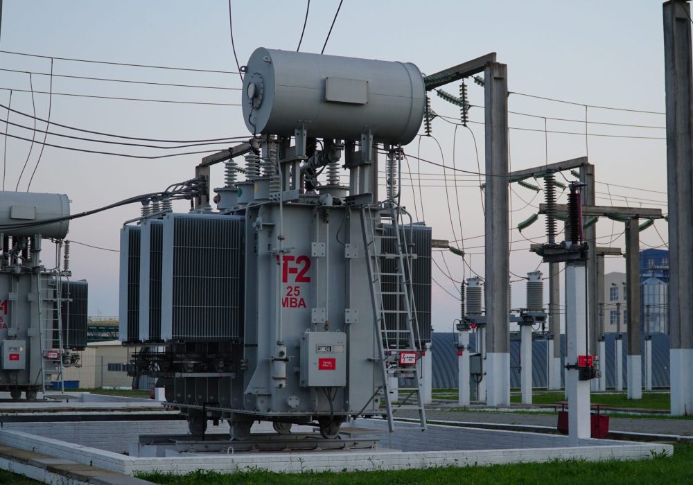 Power transformer. Electrical equipment. Electric substation. High voltage transformer against the blue sky. Electric current redistribution substation.